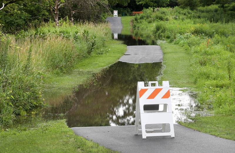 Parts of the DeKalb Nature Trail near the Kishwaukee River in Hopkins Park is blocked off after flooding Tuesday, July 16, 2024, in DeKalb after the severe thunderstorms this week have dumped heavy rains on the area. The storms caused localized damage and flooding throughout DeKalb County.