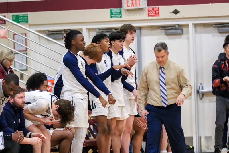 The Oswego East bench cheers on the team during Class 4A Lockport Regional final game between West Aurora at Oswego East.  Feb 24, 2023.