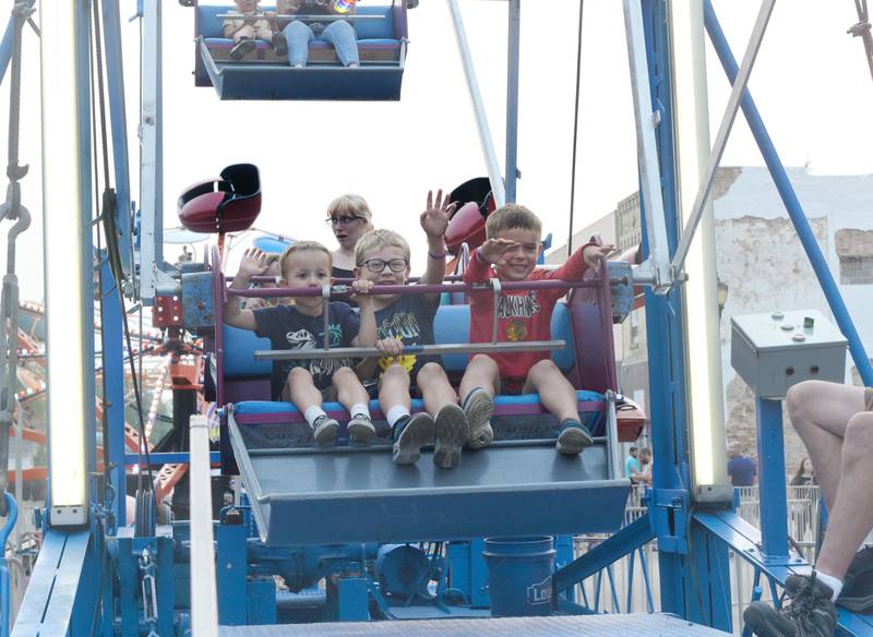 The Griffin and Sanders boys from Polo wave to their families as they take a ride on the ferris wheel at the Town & Country Days carnival in Polo on Thursday, June 15. Pictured are Briggs Griffin, 4, Ryan Griffin, 6, and Brady Sanders, 6.