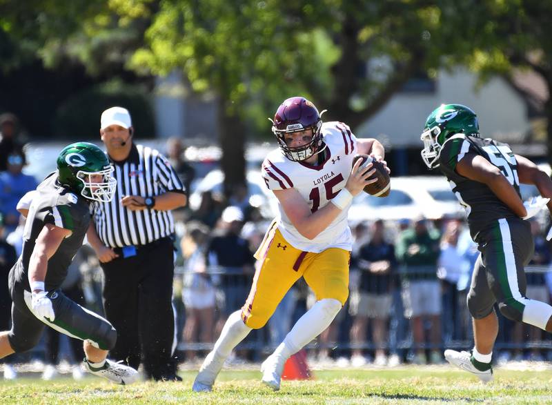 Loyola quarterback Ryan Fitzgerald (15) scrambles between Glenbard West tacklers Maximus Hetlet and Jayden Daniel (55) during a game on September 7, 2024 at Glenbard West High School in Glen Ellyn.