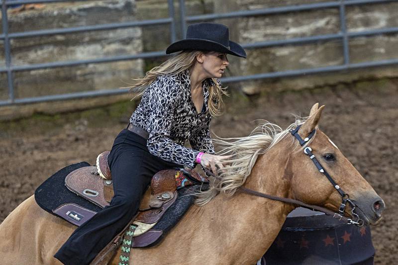 Colleen Christian makes her final turn in the Rice Bull Riding and Barrel Racing event Thursday, August 11, 2023 at the Carroll County fair.