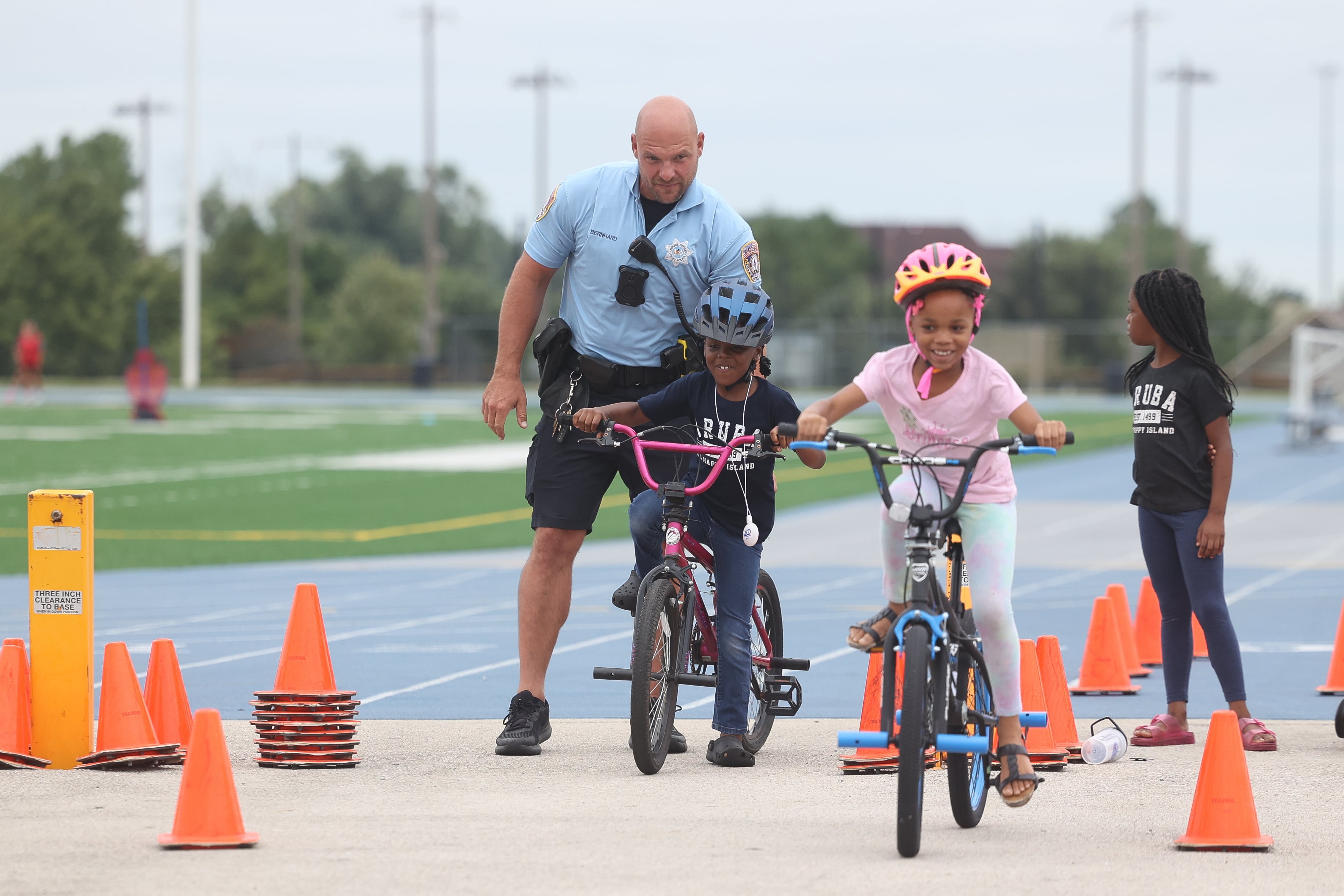 Office Eric Bernhard helps a couple kids at the bike obstacle course at Joliet Police Department’s National Night Out on Tuesday, Aug. 6, 2024.