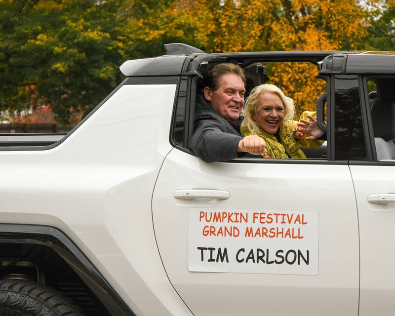 Grand Marshall of the Sycamore Pumpkin Festival parade Tim Carlson and his wife wave to parade goers on Sunday Oct. 29, 2023.