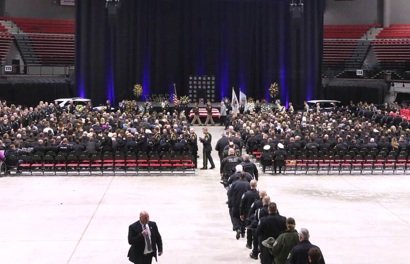 Law enforcement members file in for a walk through Thursday, April 4, 2024, during the visitation and funeral for DeKalb County Sheriff’s Deputy Christina Musil in the Convocation Center at Northern Illinois University. Musil, 35, was killed March 28 while on duty after a truck rear-ended her police vehicle in Waterman.
