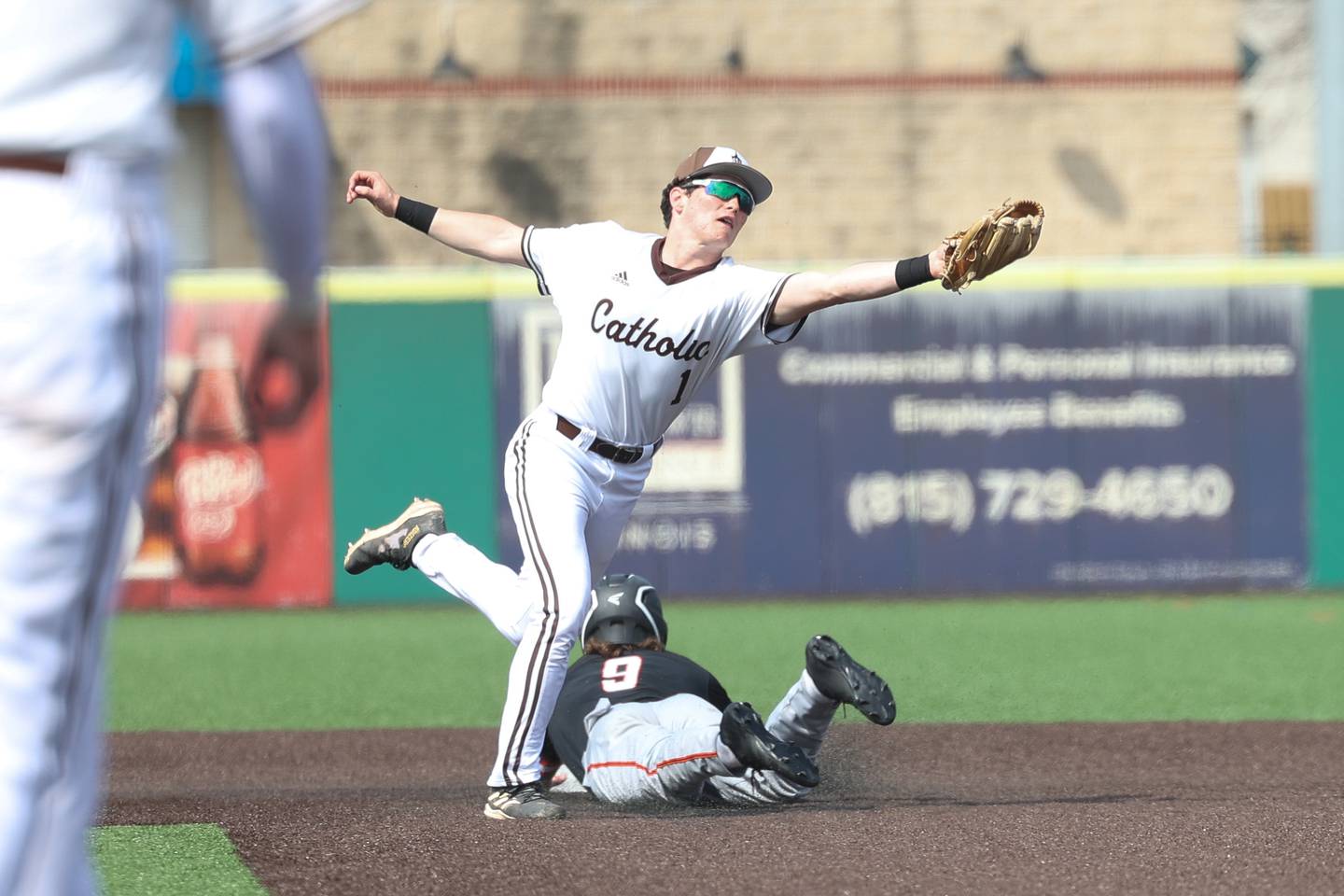 Joliet Catholic’s Lucas Simulick reaches for the wide throw against Minooka in the WJOL tournament championship on Saturday, March 30, 2024 in Joliet.