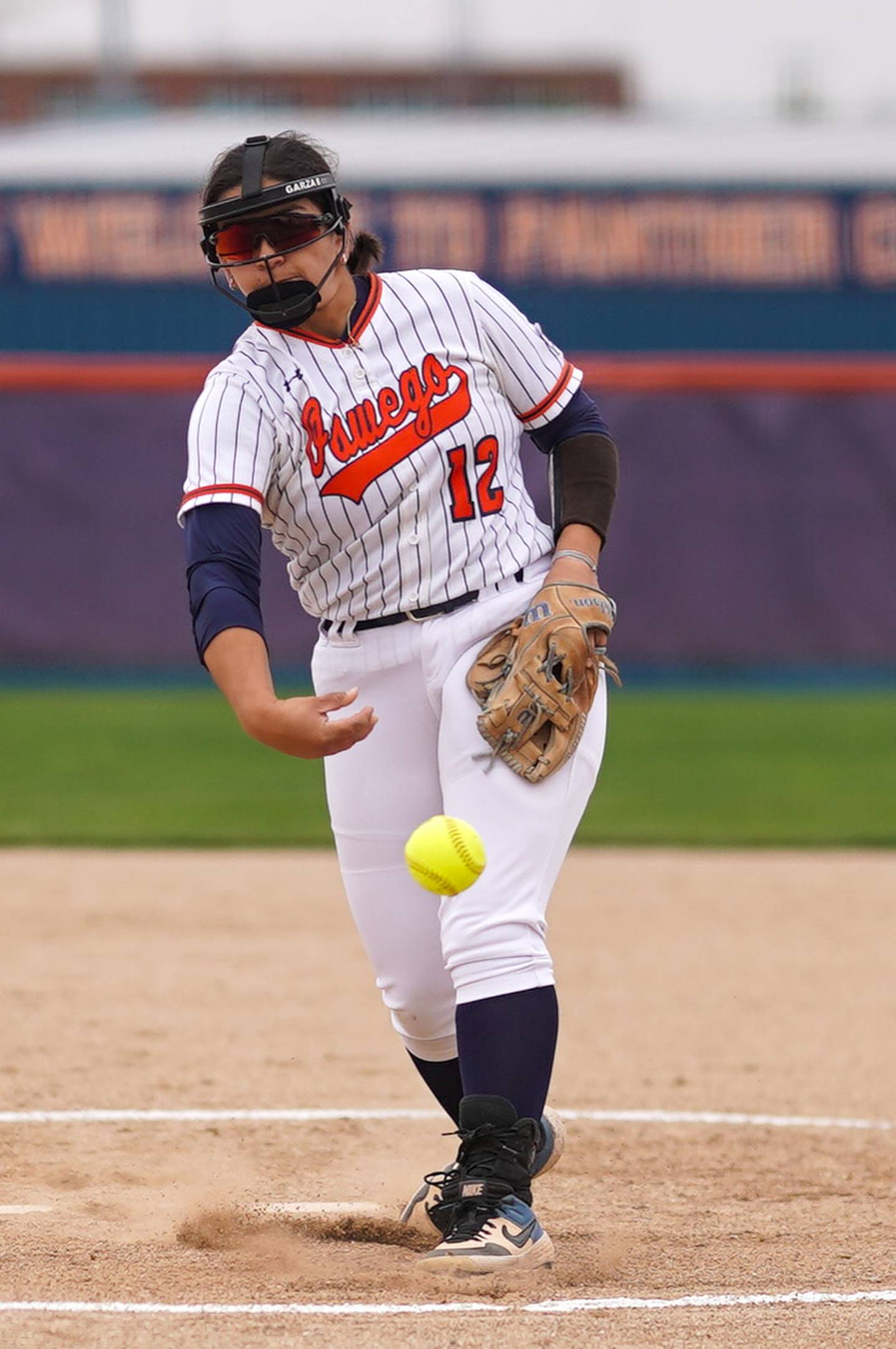 Oswego’s Aubriella Garza (12) delivers a pitch against Oswego East during a softball game at Oswego High School on Thursday, April 18, 2024.