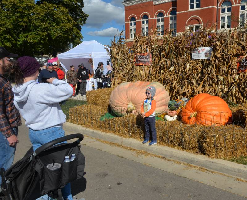 Aiden McGinnis, 4, of Byron, poses for a photo by Theresa Miller's big pumpkin's for a photo on Saturday, Oct. 7, 2023 during Autumn on Parade.