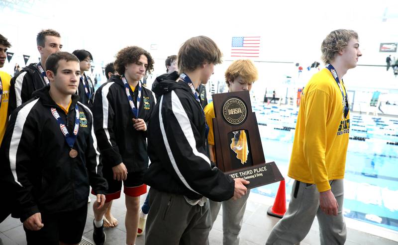 Stevenson swimmers carry their third-place trophy following the IHSA Boys State Championships at FMC Natatorium in Westmont on Saturday, Feb. 25, 2023.