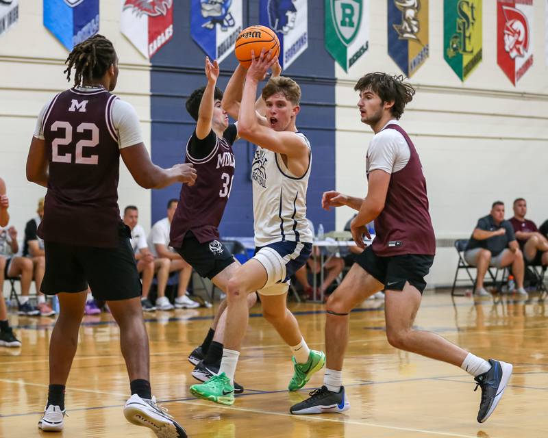 Lemont's Gabe Sularki splits the defense on the way to the basket at the Riverside-Brookfield Summer Shootout basketball tournament. June 22, 2024.