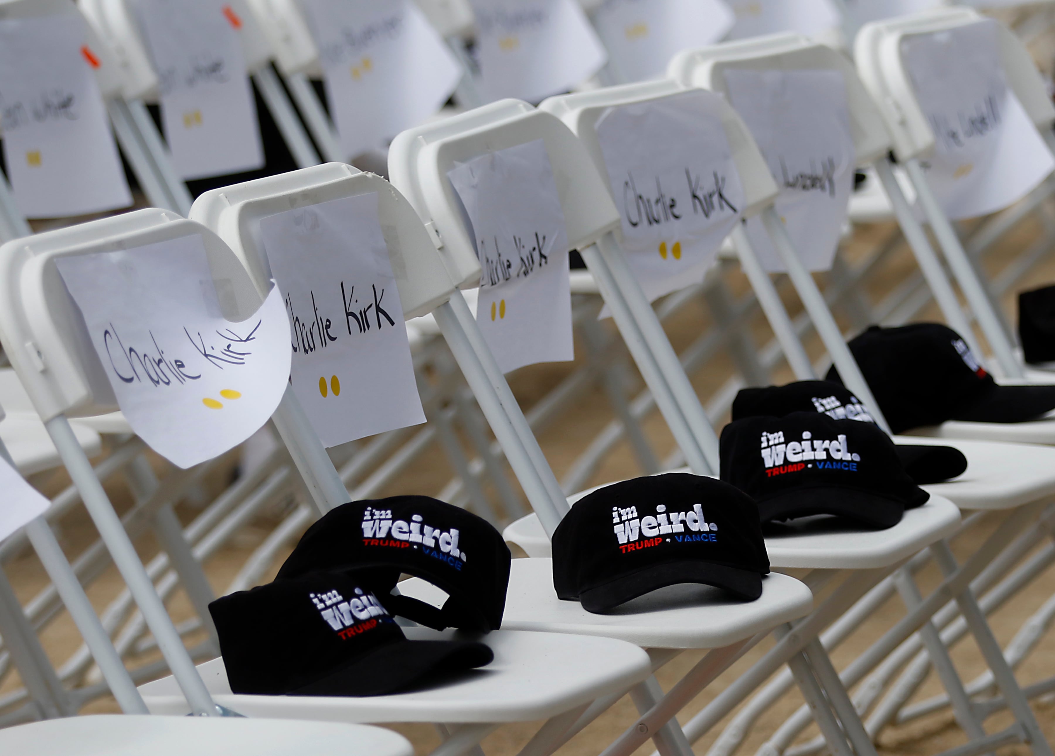 “I'm Weird” hats on chairs with Charlie Kirk’s name on them during the Trump Now-Save the American Dream Rally at the McHenry County Fairgrounds on Sunday Aug. 18, 2024, in Woodstock.