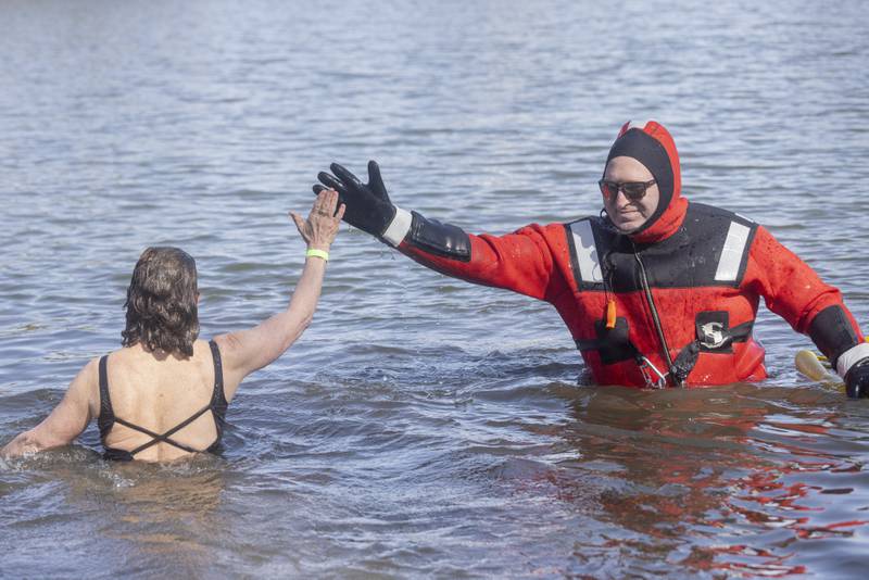 A rescue diver congratulates Lisa Johnson who was the last plunger during the Special Olympics Polar Plunge at Lake Mendota on February 24, 2024.