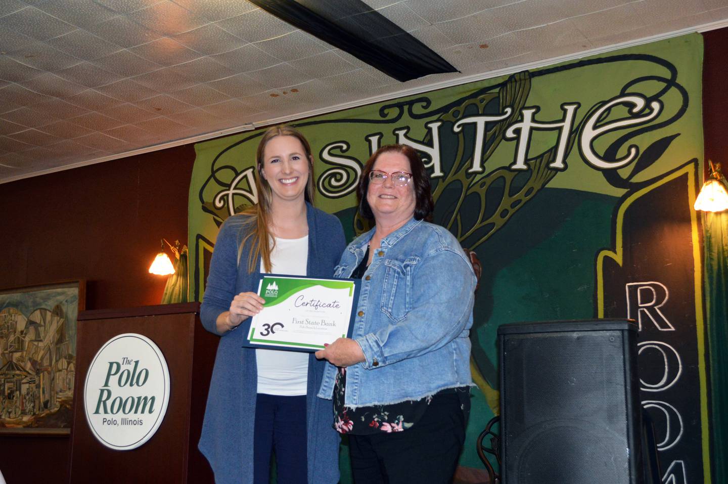 First State Bank Polo Branch Manager Pam White, right, accepts a certificate of recognition of the bank's 30-year anniversary from Polo Chamber of Commerce Executive Secretary Megan White during the Chamber's 56th annual meeting and dinner on Sept. 27, 2023.