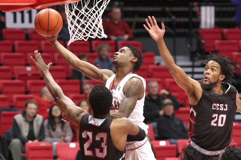 Northern Illinois' Xavier Amos scores between two Calumet defenders during their game Monday, Dec. 18, 2023, at the Convocation Center at NIU in DeKalb.