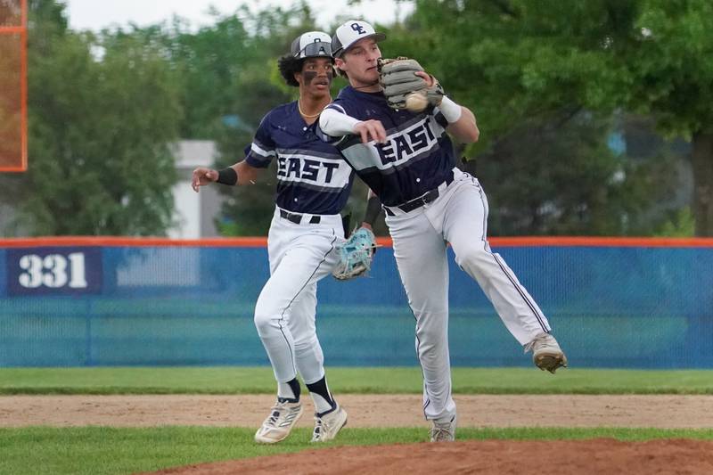 Oswego East's Christian Martyn (30) fields a grounder with his hand and throws to first for an out during a baseball game against Oswego at Oswego High School on Monday, May 13, 2024.