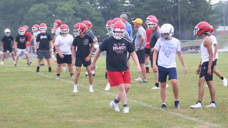 Hall football players warm up before practice on Tuesday, July 9, 2024 at Hall High School.