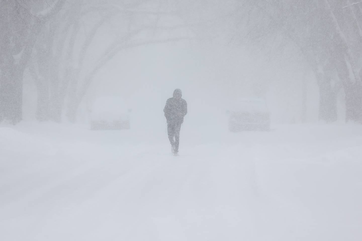 A pedestrian walks down the middle of Oneida Street as heavy snows continue to fall. Wednesday, Feb. 2, 2022, in Joliet.