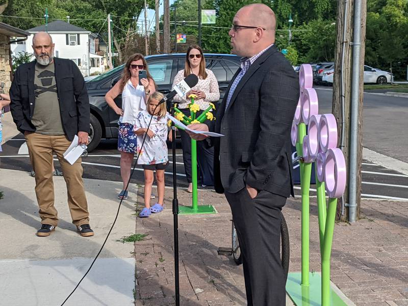 Oswego Village President Ryan Kauffman speaks at a June 27 presentation celebrating two outdoor public art projects in downtown Oswego initiated by the Oswego Cultural Arts Commission.