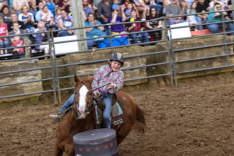 Carlyn Vondra makes her final turn in the Rice Bull Riding and Barrel Racing event Thursday, August 11, 2023 at the Carroll County fair.