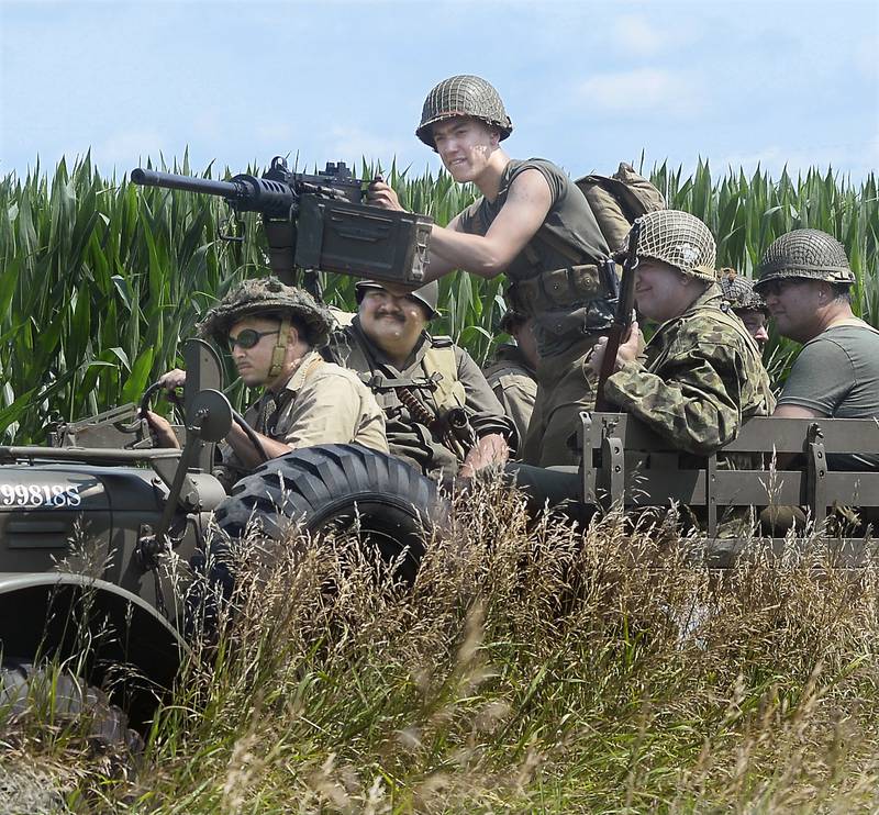 A group of Allied soldiers ride on patrol looking for enemy while in a World War ll reenactment battle Saturday, July 15, 2023, during the fourth annual Ottawa Military Show, north of Ottawa. Military displays and vehicles that the public could ride and a parade through Ottawa were part of the weekend event.