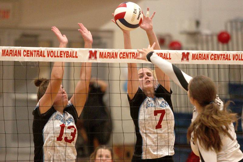 Marian Central’s Lucy Iden (13) and Jordan Orlos (7) block against Grayslake North in girls volleyball in Woodstock Monday.