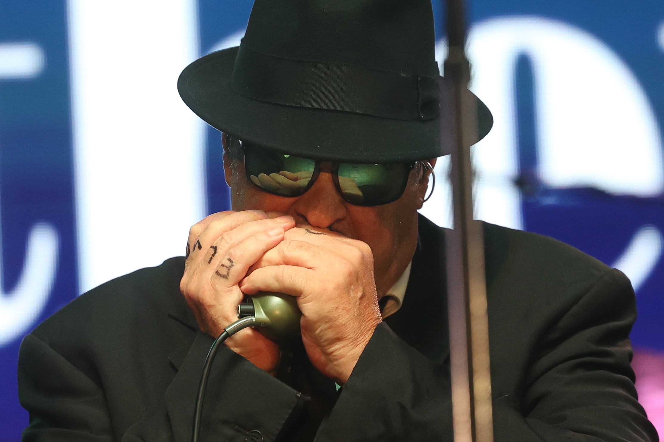 Dan Aykroyd, aka Elwood Blues, plays the harmonica at Blues Brothers Con: The Sequel on Saturday, Aug. 17, 2024 at the Old Joliet Prison.