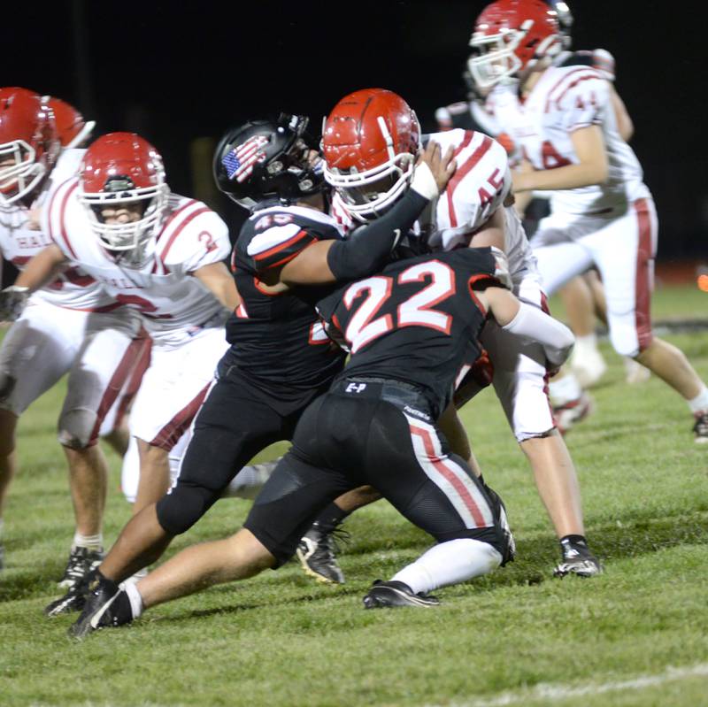 Erie-Prophetstown's Tristan Hovey (22) and Jordae Crow (45) wrap up Hall's Aidan McMahon (45) during a Friday, Sept. 6, 2024 game in Prophetstown.