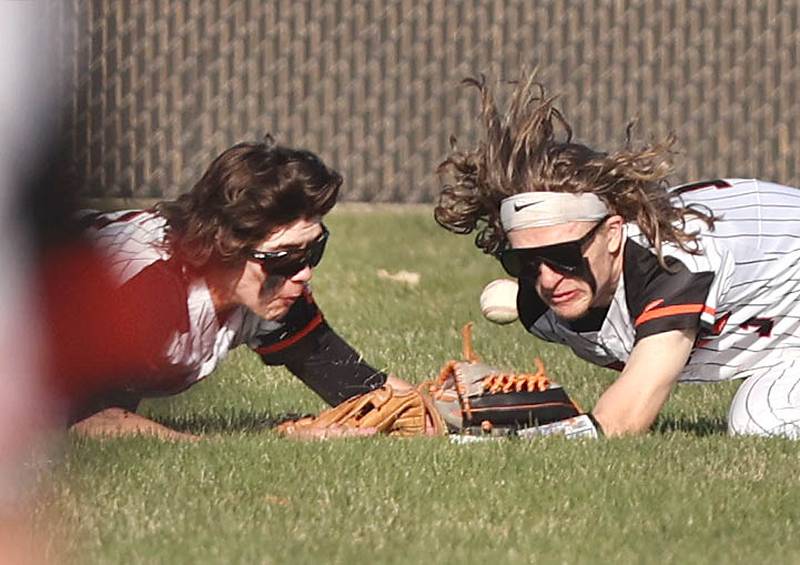 DeKalb's Cole Latimer (left) and Landon Simonson collide while diving for a ball during their game against Metea Valley Thursday, April 13, 2023, at DeKalb High School. Both injured players were able to stay in to finish the inning. Both injured players were able to stay in to finish the inning.