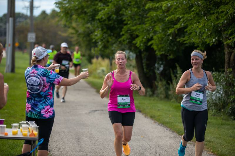 Fox Valley Marathon runners turn down mimosas from the mimosa tent on the trail in St. Charles on Sunday, Sept. 18, 2022.