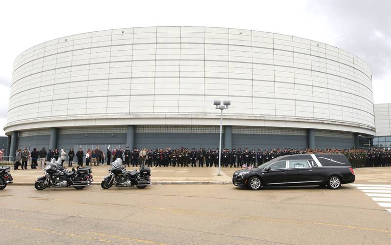Members of law enforcement wait outside the Convocation Center at Northern Illinois University Thursday, April 4, 2024, for the casket of DeKalb County Sheriff’s Deputy Christina Musil to be brought to the hearse following her visitation and funeral. Musil, 35, was killed March 28 while on duty after a truck rear-ended her police vehicle in Waterman.