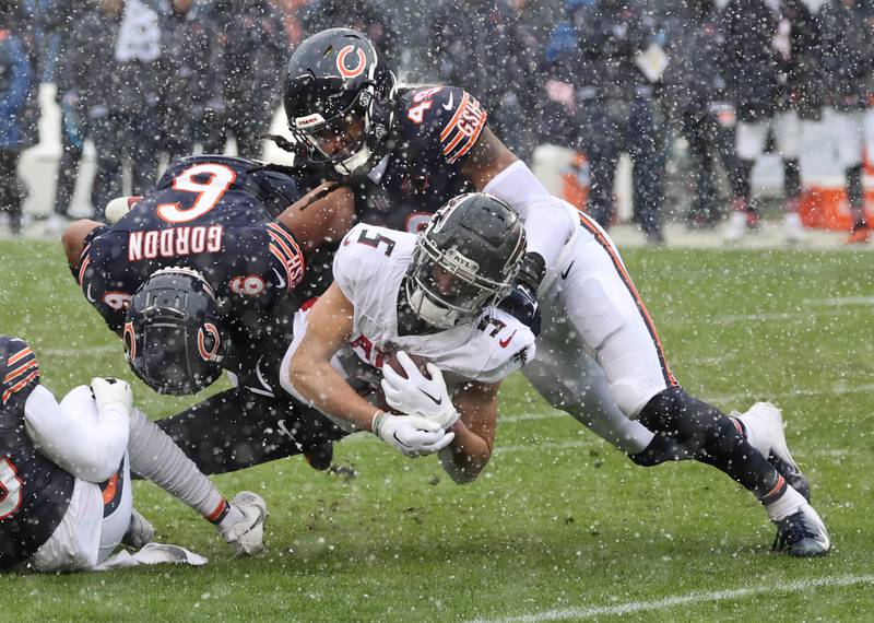 Chicago Bears cornerback Kyler Gordon and linebacker Tremaine Edmunds bring down Atlanta Falcons wide receiver Drake London during their game Sunday, Dec. 31, 2023, at Soldier Field in Chicago.