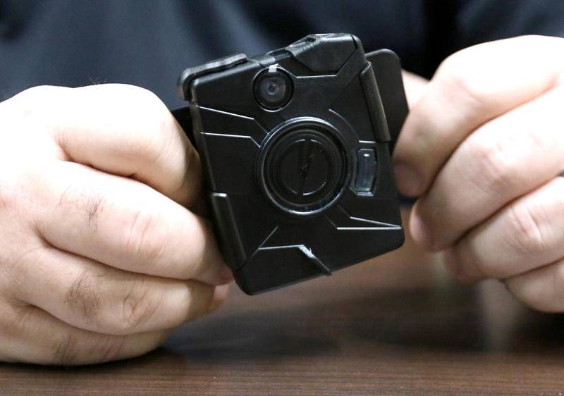 DeKalb police Cmdr. Craig Woodruff holds one type of body camera Thursday at the department, and said that the department will begin a pilot body-camera program that was approved for the fiscal 2020 city budget.