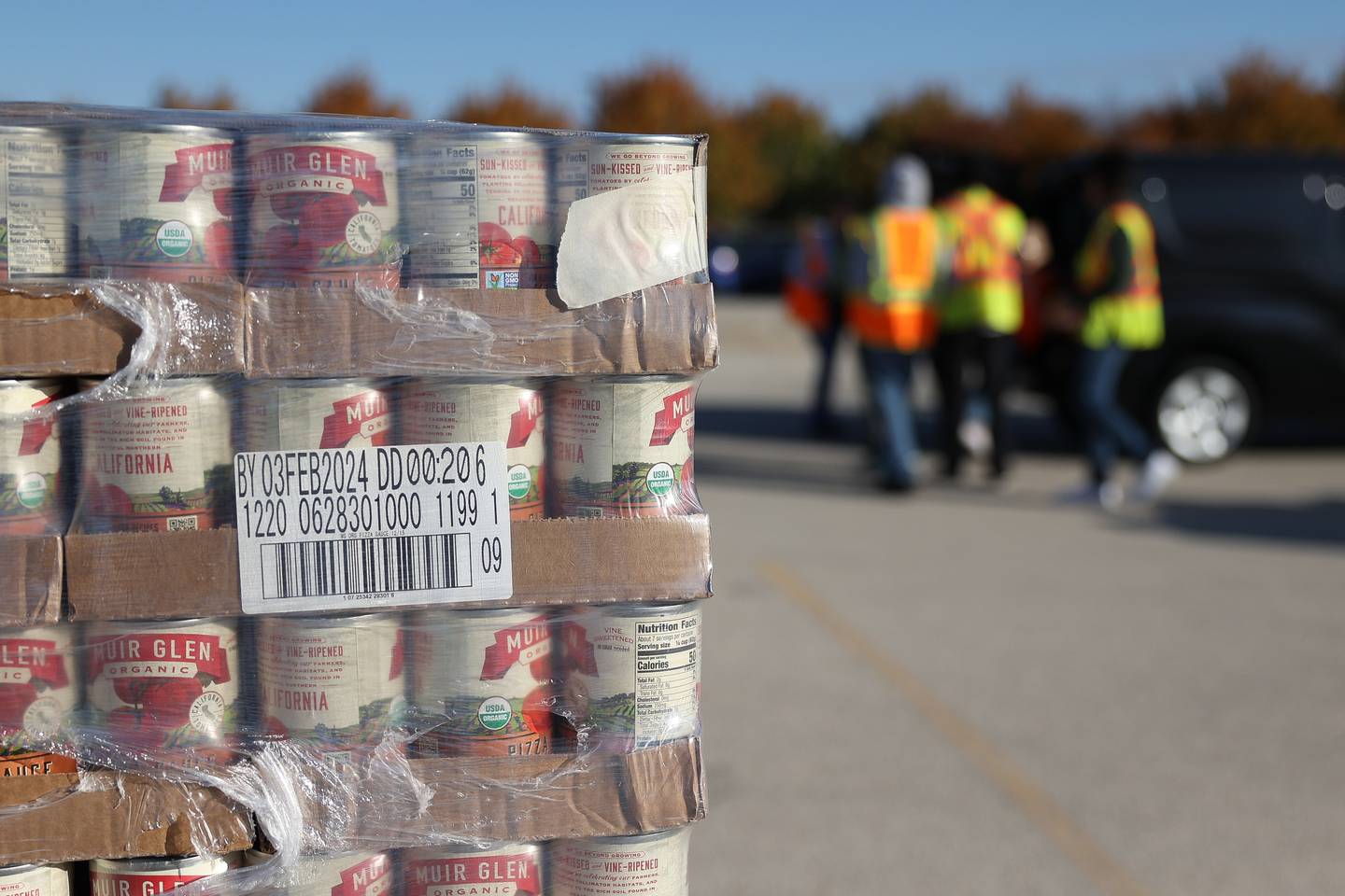 Canned goods sit stacked in the parking lot at Joliet Junior College as volunteers load a car with groceries on Saturday, Oct. 21. With inflation and rising food costs, Northern Illinois Food Bank held a Free PopUp Grocery Distribution giving away groceries to 700 families.