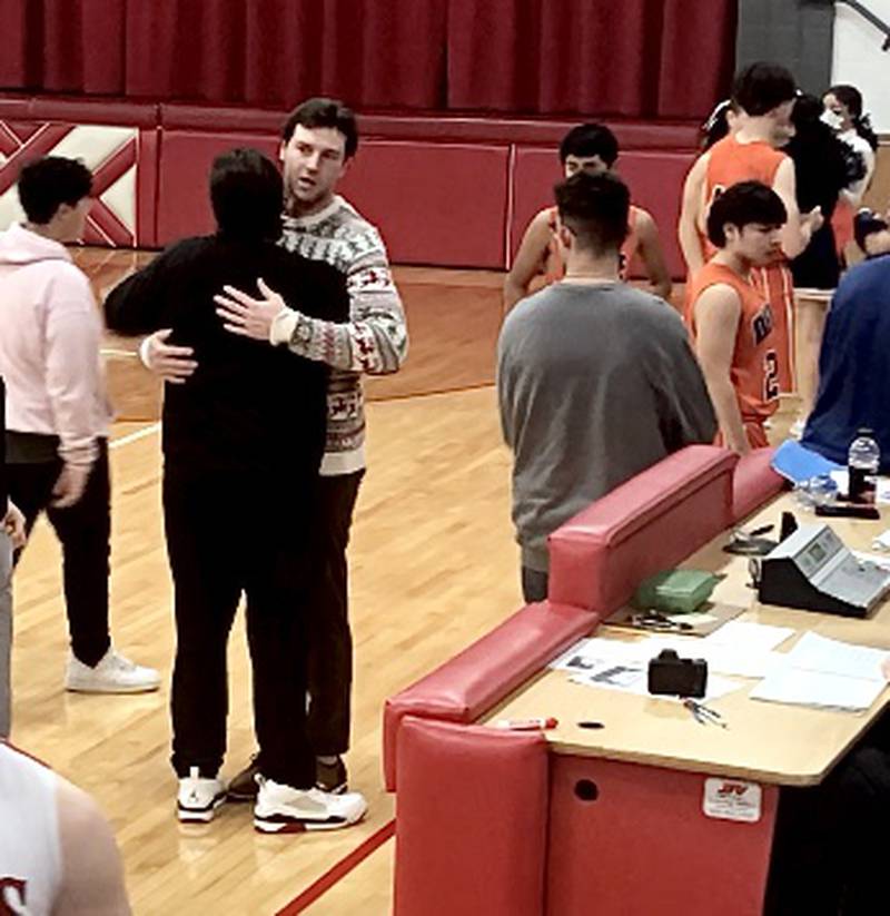 DePue coach Trae Blumhorst hugs his brother, LaMoille coach Chance Blumhorst, after Friday's game in LaMoille.