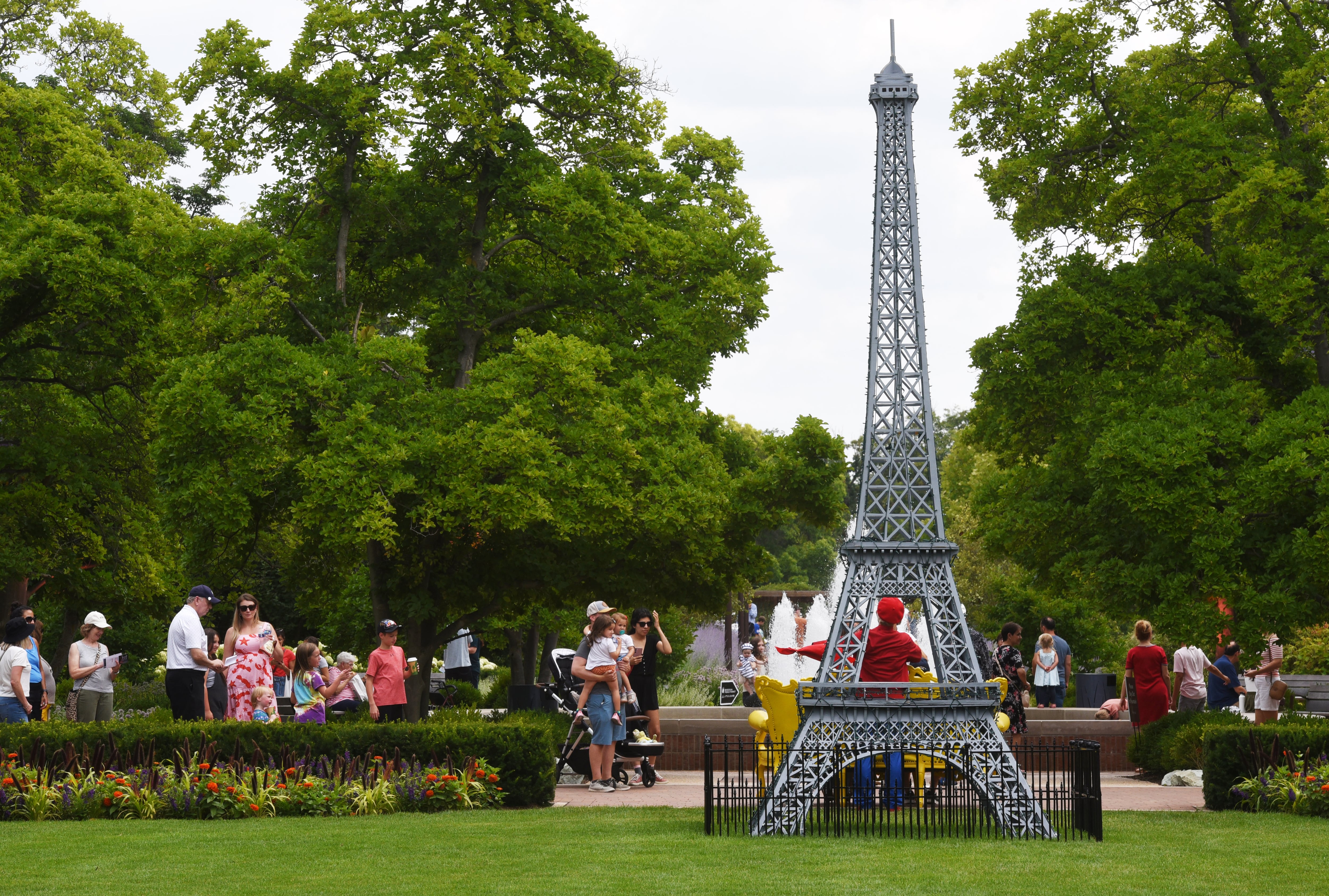 Visitors stop to view a scaled-down replica of the Eiffel Tower during the Voyage en France event at Cantigny Park in Wheaton on Saturday, July 20, 2024 in Wheaton.