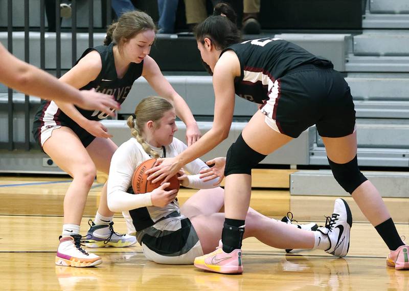Prairie Ridge's Ali Storz (left) and Addie Meyer surround Kaneland's Kendra Brown Thursday, Feb 15, 2024, during their Class 3A regional final game at Kaneland High School in Maple Park.