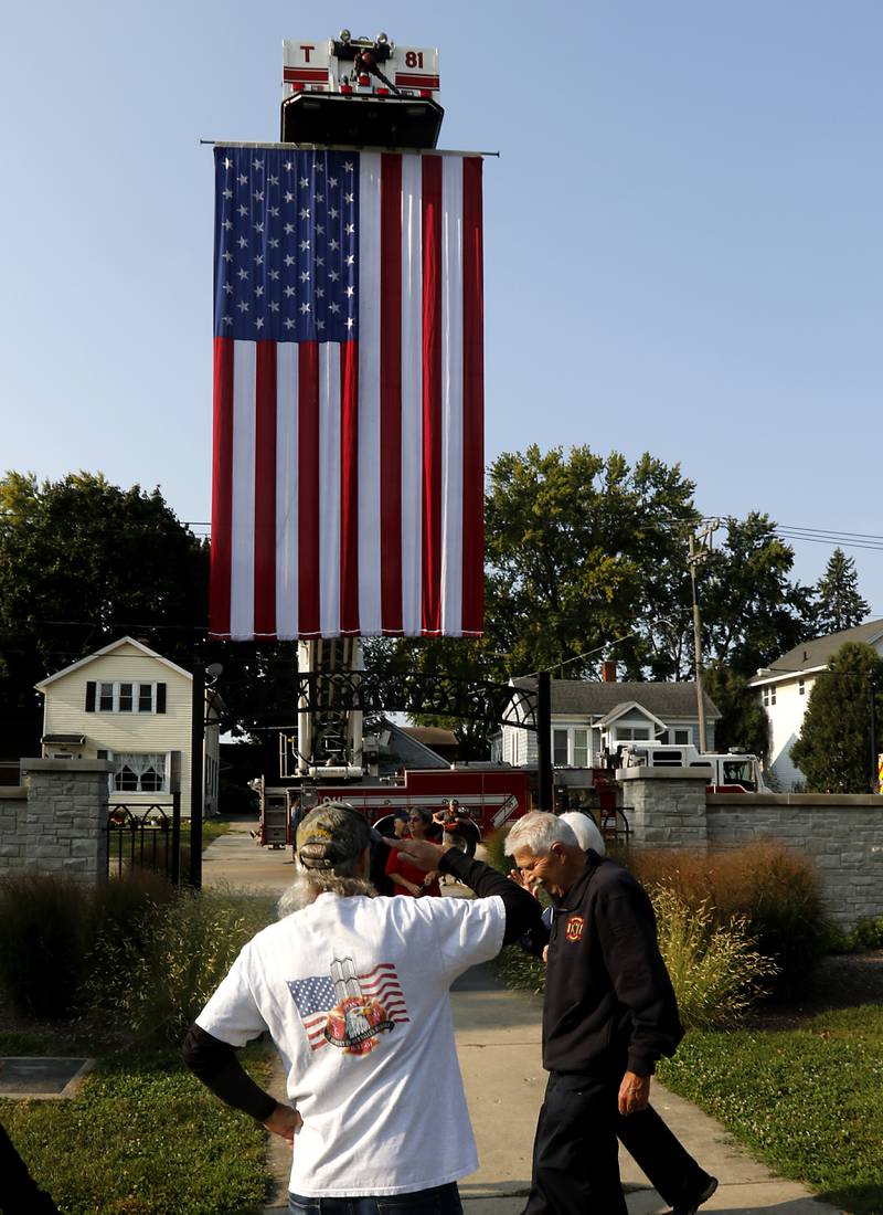 Retired Chicago firefighter Tim Sobus of Johnsburg salutes other firefighters during the during a 9/11 remembrance ceremony on Sept. 11, 2024, at Veteran's Memorial Park in McHenry.