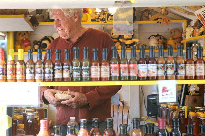 Owner and operator of Audi's Acres Natural Farm, Ed Wonsowski interacts with customers at the Honey Booth during the Sandwich Fair on Saturday, Sept. 9, 2023. The booth has been at the fair since 1949.