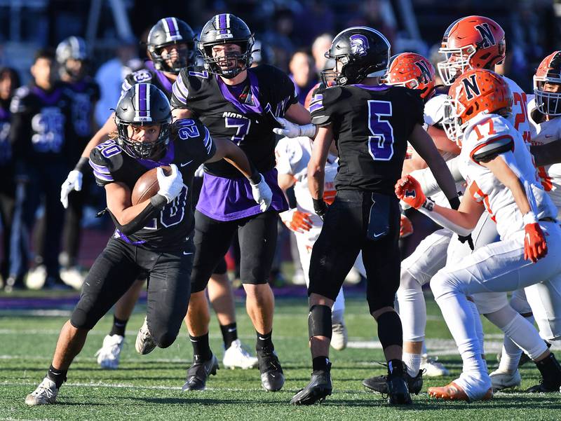 Downers Grove North's Noah Battle (20) breaks through the line for first down yardage during an IHSA Class 7A semifinal game against Normal Community on Nov. 18, 2023 at Downers Grove North High School in Downers Grove.
