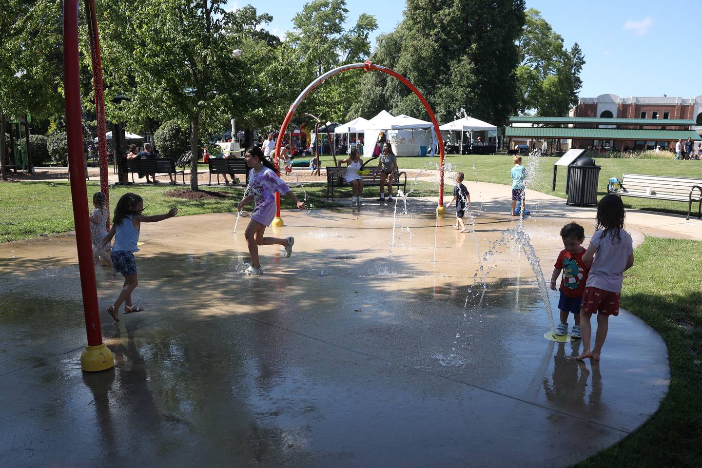 Kids play at the splash pad at the Villge Green Park during Plainfield Fest on Saturday June 29, 2024.