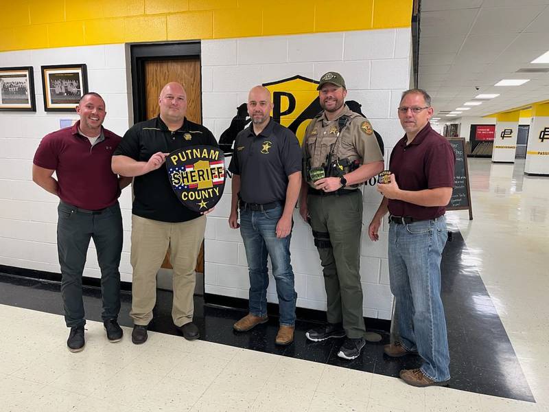 Putnam County Sheriff Josh Boedigheimer, Sgt Brett Calbow and Deputy Tim Pyszka met with art teacher Joshua Curry and Principal Dustin Schrank to present them with a replica of the sheriff's office's new patch to display in the classroom.