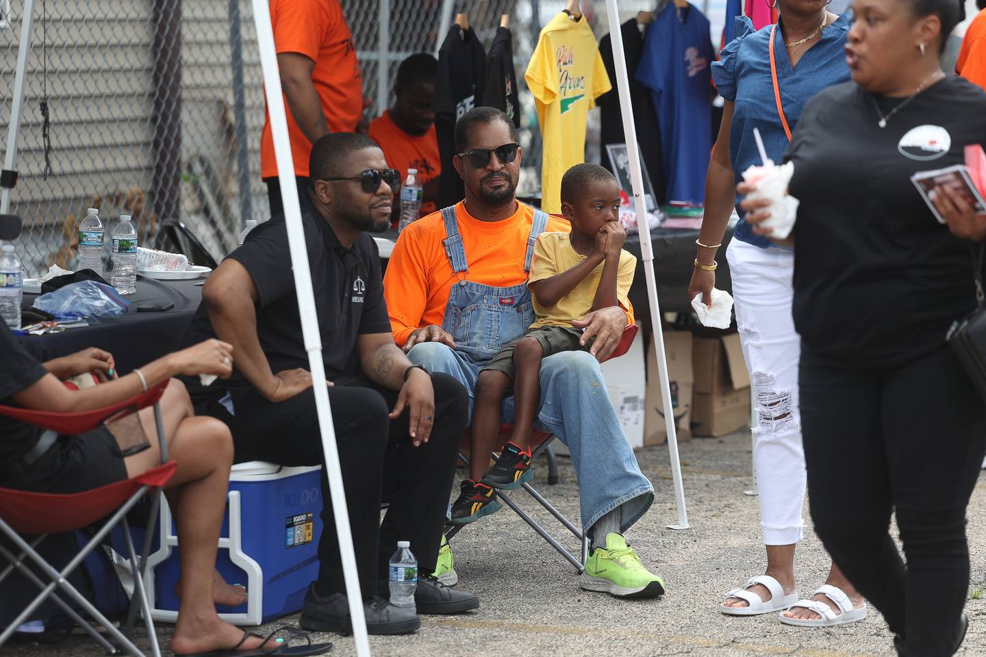 DaMarcus Allen, center, holds his son Isaiah while sitting with his cousin Jerry King at the Healing the Hood event held at the St. Mark CME Church in Joliet on Saturday June 29, 2024.