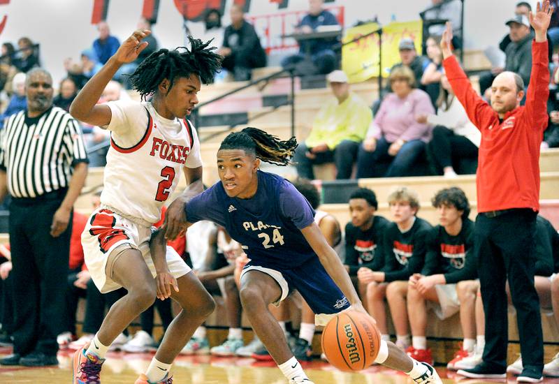 Plano's Amari Bryant (25) drives the baseline against Yorkville defender Michael Dunn (2) during a varsity basketball game at Yorkville High School on Tuesday, Dec. 19, 2023.