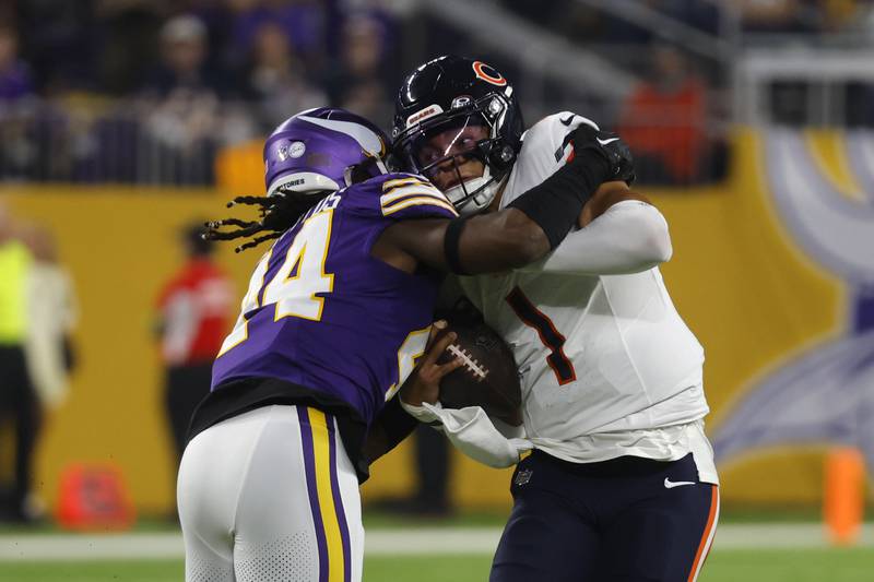 Chicago Bears quarterback Justin Fields is tackled by Minnesota Vikings safety Josh Metellus during the first half, Monday, Nov. 27, 2023, in Minneapolis.