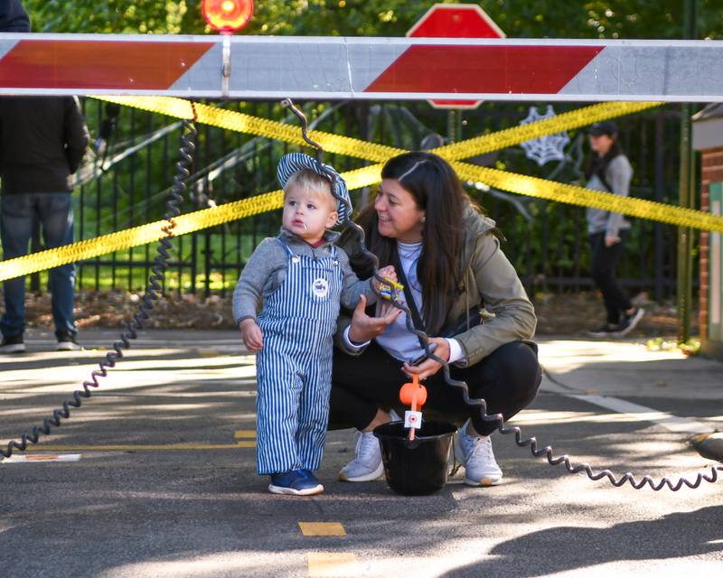 Lucas Felden, of Elmhurst watches the train gate operate with his mom Brittany Feldon as guest trick or treat in the safety town section of the Family Fall Fest held at Wild Meadow Trace Park in downtown Elmhurst on Saturday Oct. 7, 2023.