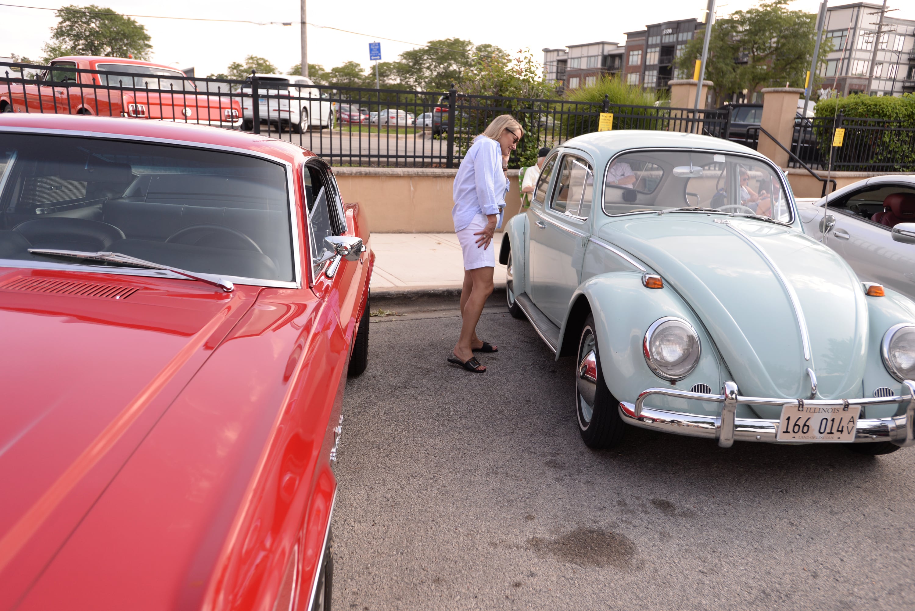 Kim Matreci of St. Louis takes a closer look at a 1965 Volkswagen while attending the Downers Grove Car Show Friday July 19, 2024.