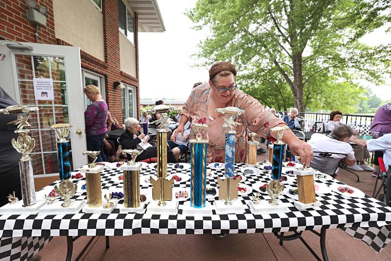 Amanda Wolfe, dietary manager, checks out the trophies given to the winners of the decorated cars during Franklin Grove Assisted Living’s car show Friday, June 23, 2023.