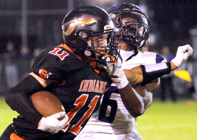 Sandwich running back Nick Michalek (11) stiff arms Plano defender Waleed Johnson (6) during a varsity football game at Sandwich High School on Friday, Sept. 8, 2023.