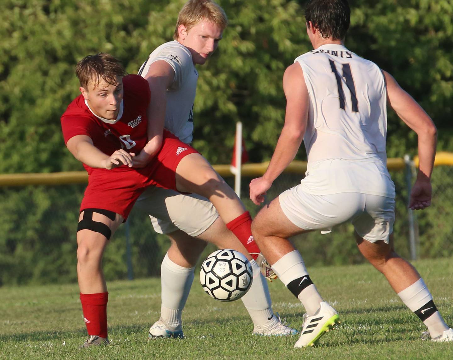 Streator's Noah Russow kicks the ball away from Bloomington Central Catholic's Warren Tomczak and Brad Torry on Wednesday, Aug. 23, 2023 at St. James Street Recreation Area in Streator.