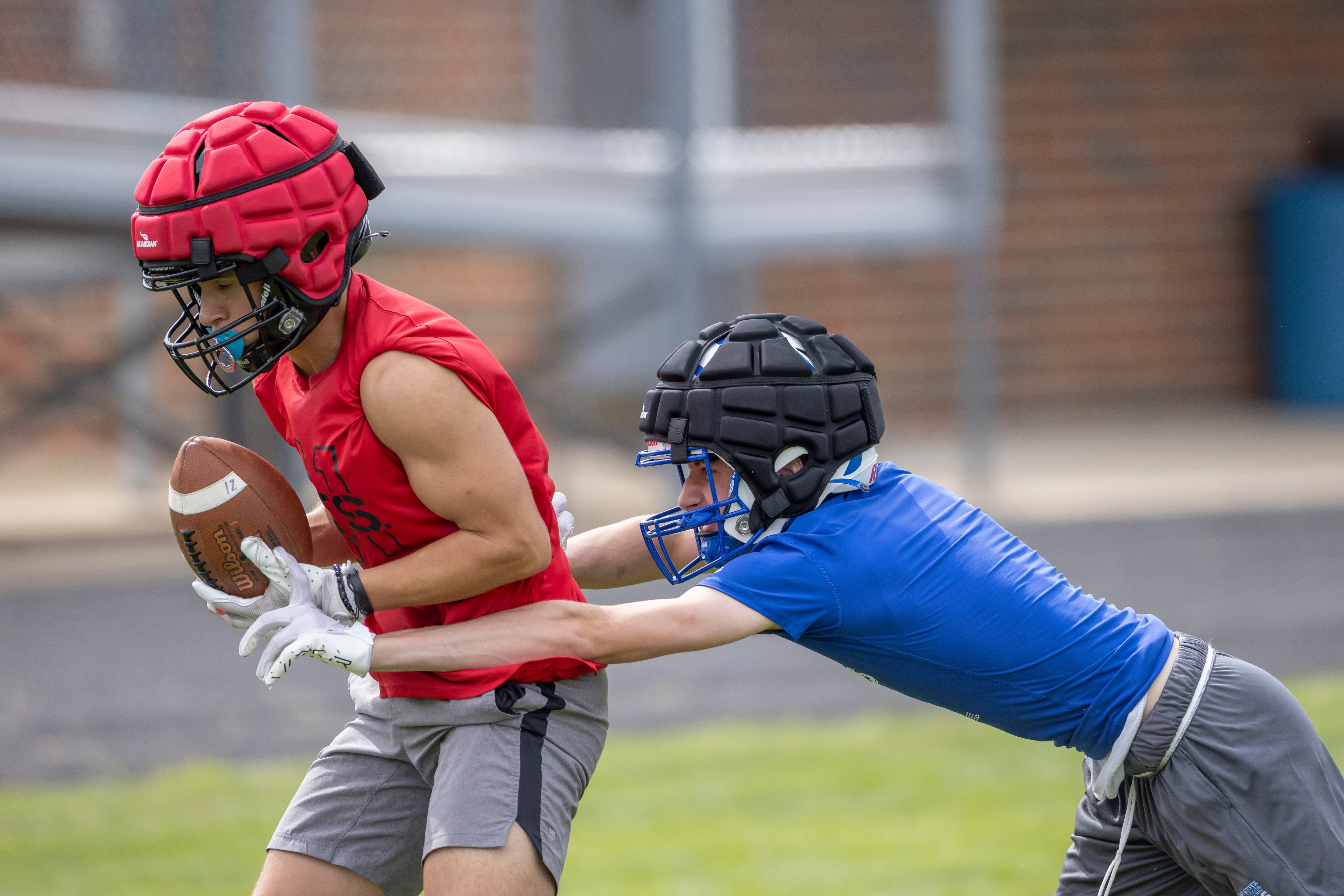 A Princeton athlete applies tag to down Eden Cot of Metamora High School after making the catch during a multiple high school practice football meet at Princeton High School on July 20, 2024.