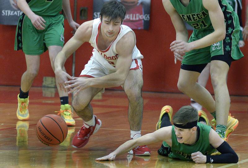 Streator’s Christian Benning and Seneca’s Paxton Giertz dive for a loose ball in the 1st period in Pops Dale Gymnasium on Tuesday Feb. 7, 2023 at Streator High School.